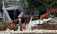 Anggota TNI, Satpol PP, Kopassus, dan kepolisian bahu-membahu menutup tanggul yang jebol. Rachman Haryanto/detikFoto.