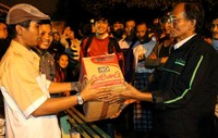 Pimpinan Scoodenttial Wilayah Rawamangun Bro Soerya Wadi menyerahkan bantuan kepada korban banjir. (Loretta Ariati).