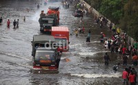 Sejumlah warga berusaha melintasi banjir di Jalan Jembatan 3, Pluit Jakarta Utara.     