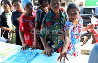 Warga korban banjir mengantre obat di posko kesehatan.