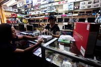 Seorang pedagang sedang melayani pembeli.