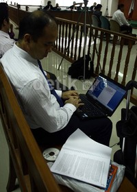 Hotasi Nababan mengerjakan naskah pembelaannya sebelum sidang dimulai. Ramses/detikFoto.