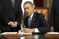 Obama menandatangani sumpah jabatan. Reuters/Jonathan Ernst.