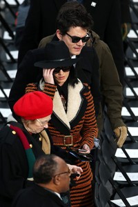 Pelantun 'Wide Awake' itu terlihat mengenakan coat oranye-hitam, topi fedora, dan kacamata hitam. Alex Wong/Getty Images.