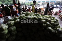 Pengunjung pasar melintas didepan jenis sayur kol, yang diletakkan didalam Pasar Induk Kramat Jati, Jakarta, Selasa (22/01). Rengga Sancaya/detikcom