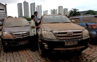 Pemilik mengecek mobilnya yang telah dipenuhi lumpur.