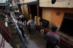 Polisi Bersih-bersih Sisa Banjir di Kampung Pulo