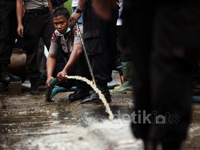 Polisi Bersih-bersih Sisa Banjir di Kampung Pulo
