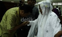 Mantan Bupati Buol, Sulteng, Amran Batalipu mencium tangan ibunya setelah sidang pembacaan pembelaan. Ramses/detikFoto.
