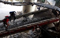 Sejumlah pekerja membongkar pondasi kabel PLN di sekitar jembatan Kalibata, Jakarta.