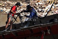 Dua orang pekerja membongkar pondasi kabel tersebut dengan cara di bor.