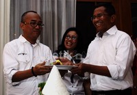 Menteri BUMN Dahlan Iskan memberikan potongan nasi tumpeng kepada Koordinator Komunitas Ayo Selamatkan Indonesia (KASI), Budi Purnomo Karjodihardjo. Ramses/detikFoto.