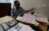 Petugas mengecek berkas para pemohon pembuatan paspor.