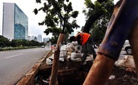 Pembersihan lumpur kering untuk mengantisipasai banjir di sepanjang jalan tersebut.