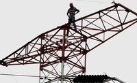 Agustinus melakukan aksi telak pinggang di atas tower SUTET, tanpa menggunakan alas kaki.