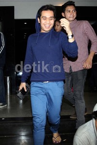 Olga yang mengenakan baju berwana biru terlihat menebar senyum kepada awak media.