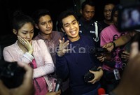 Ayu yang mengenakan baju hamil berwarna merah muda juga terlihat dengan senyuman sebelum masuk lift tersebut.