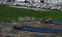 Tampak 2 alat berat melakukan proses pengerukan. Rencananya setelah dinormalisasi waduk ini menurut Gubernur Jokowi akan dijadikan tempat wisata.          