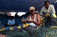 Buruh ini dibayar Rp 130 rb/perhari untuk memperbaiki jaring.