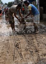 Warga Bersihkan Lumpur Sisa Banjir