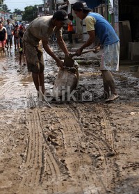 Dengan alat seadanya mereka membersihkan lumpur yang bisa membahayakan para pengendara tersebut.
