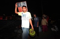 Di bawah langit yang telah gelap mereka mengevakuasi barang-barang dari amukan api.