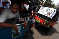 Mereka membawa poster-poster yang ditempelkan di bajaj.