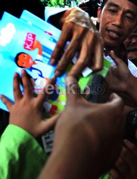 Anak-anak berebut buku yang dibagikan Jokowi.
