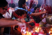 Warga Tionghoa membakar dupa sebelum berdoa.