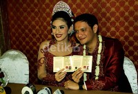 Jika saat akad nikah Eno dan Nadila tampil dengan busana serba putih, pada resepsi mereka memilih warna merah marun.