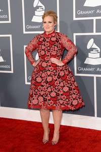 Adele tampak mencolok dengan dress merah muda bermotif bunga Valentino dan sepatunya yang terlihat serasi. Jason Merritt/Getty Images.