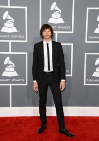 Gotye tampak rapi dengan jas dan dasi hitam serta kemeja putih. Jason Merritt/Getty Images.