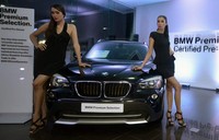 Dua orang model peraga berpose didepan mobil seken BMW bersertifikat saat peresmian dealernya di Sunter, Jakarta, Rabu (6/2). (dok. BMW)