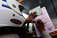 Petugas menilang salah seorang sopir yang tidak memakai seragam.