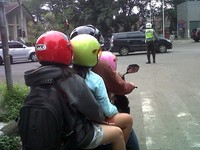 Seketika bapak tersebut disuruh polisi minggir karena melakukan pelanggaran berbonceng lebih dari 2 orang. (Foto: Ilham Adi Putra Irawan).
