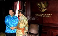 Ketua Mahkamah Konstitusi (kanan) bejabat tangan dengan Ketua Komisi Pemilihan Umum Husni Kamil Manik (kiri).