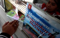 Seorang calon penumpang membeli tiket Kopaja di Halte Kuningan Timur, Jakarta