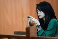 Perempuan yang tubuhnya dipenuhi dengan tato itu sibuk dengan handphone-nya.