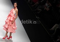 Seorang model memperagakan busana di atas catwalk.