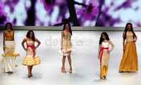 Lima orang model berlenggak-lenggok di atas catwalk.