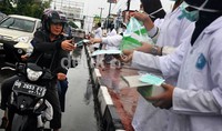 Mahasiswa Kedokteran Unismuh Makassar membagikan masker gratis pada pengendara sepeda motor untuk mencegah terjangkitnya penyakit ISPA yang kini marak diidap warga Makassar.