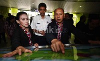 Rieke dan Teten melihat peta rute kereta api di Stasiun Gambir, Jakarta.