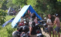 Warga mendirikan tenda pengungsian di tanggul sungai.