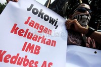 Massa HTI membawa poster dan spanduk tuntutan.