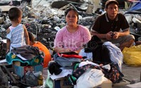 Sebagian warga bertahan di depan rumahnya yang hangus terbakar.