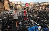 Beberapa anak membantu orangtuanya mencari barang-barang yang masih bisa dipakai.