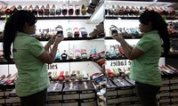 Reska Dayanti menanta sepatu buatan China di toko Three Ladies, Blok M Square, Jakarta Selatan.