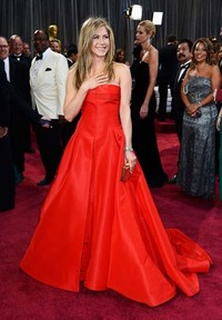 Jennifer Aniston memilih gaun merah rancangan Valentino. Frazer Harrison/Getty Images.