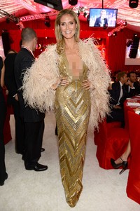 Saat berada di dalam, Heidi memadukan gaunnya itu dengan mantel bulu. (Getty Images).