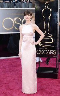 Anne Hathaway tampak cantik dalam balutan gaun soft pink Prada. Kevork Djansezian/Getty Images.